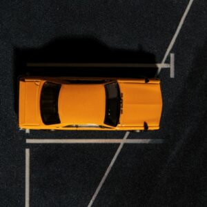 an overhead view of a yellow car parked in a parking lot