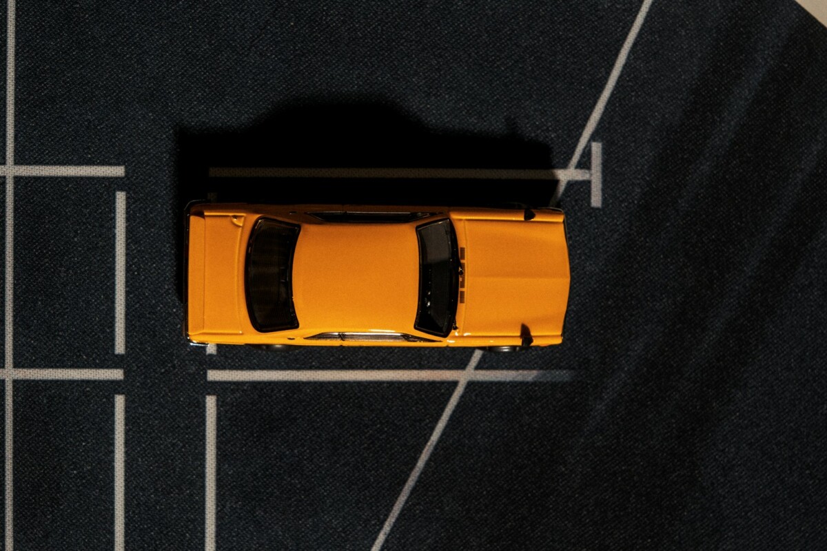 an overhead view of a yellow car parked in a parking lot