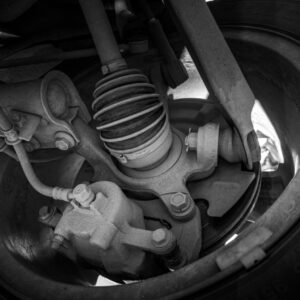 Close-up view of a car's suspension system and wheel.