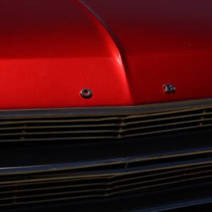 Close-up of a red car's chrome grille and hood