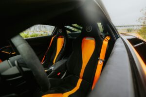 Interior of a black sports car with orange accents