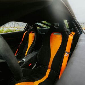 Interior of a black sports car with orange accents