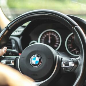 person driving bmw car during daytime