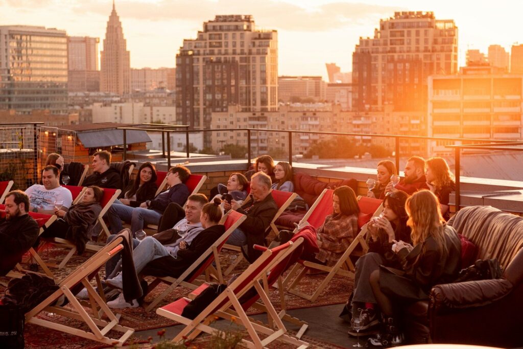 a group of people sitting in lawn chairs on top of a roof