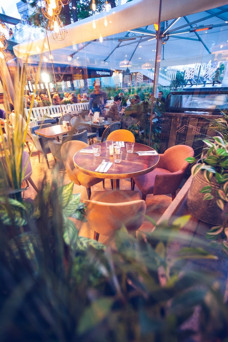 round brown wooden table with white umbrella