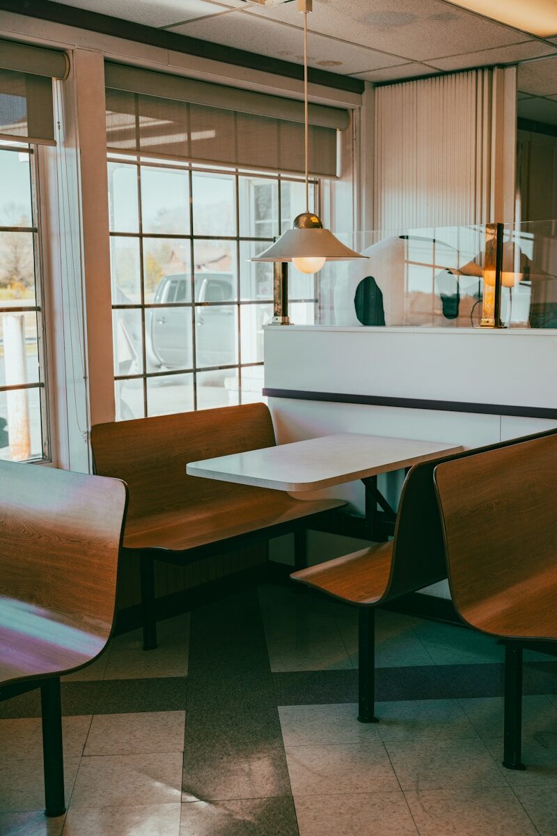a restaurant with wooden tables and chairs in front of a window