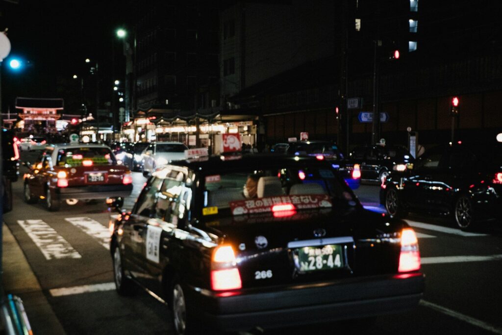 Busy city street at night with many taxis.