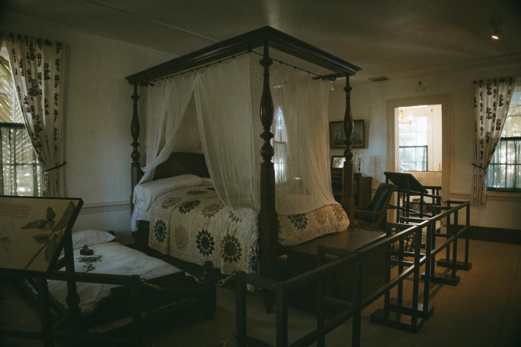 Luxurious canopy bed in a historic Key West bedroom showcasing vintage furnishings and decor.
