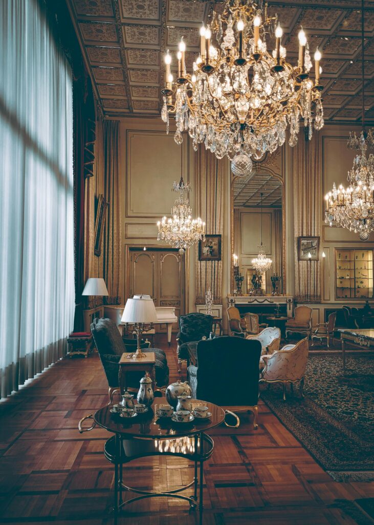 Elegant hotel lobby with vintage decor and grand chandeliers.