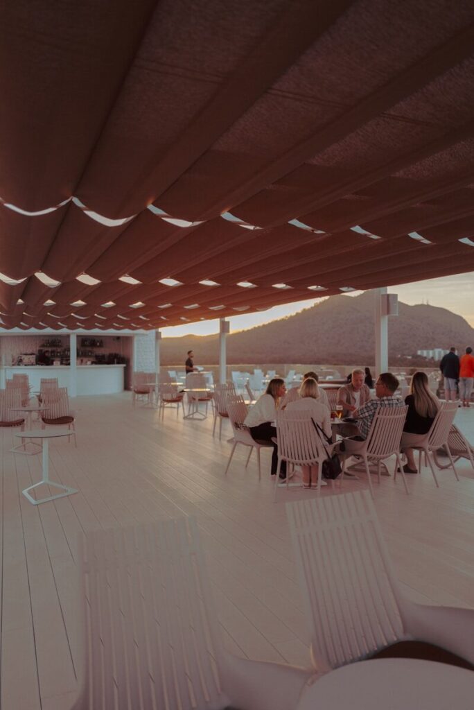 People dining at an outdoor cafe with mountain view