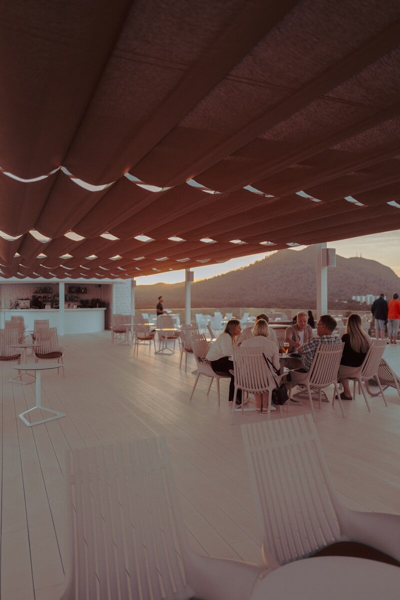 People dining at an outdoor cafe with mountain view