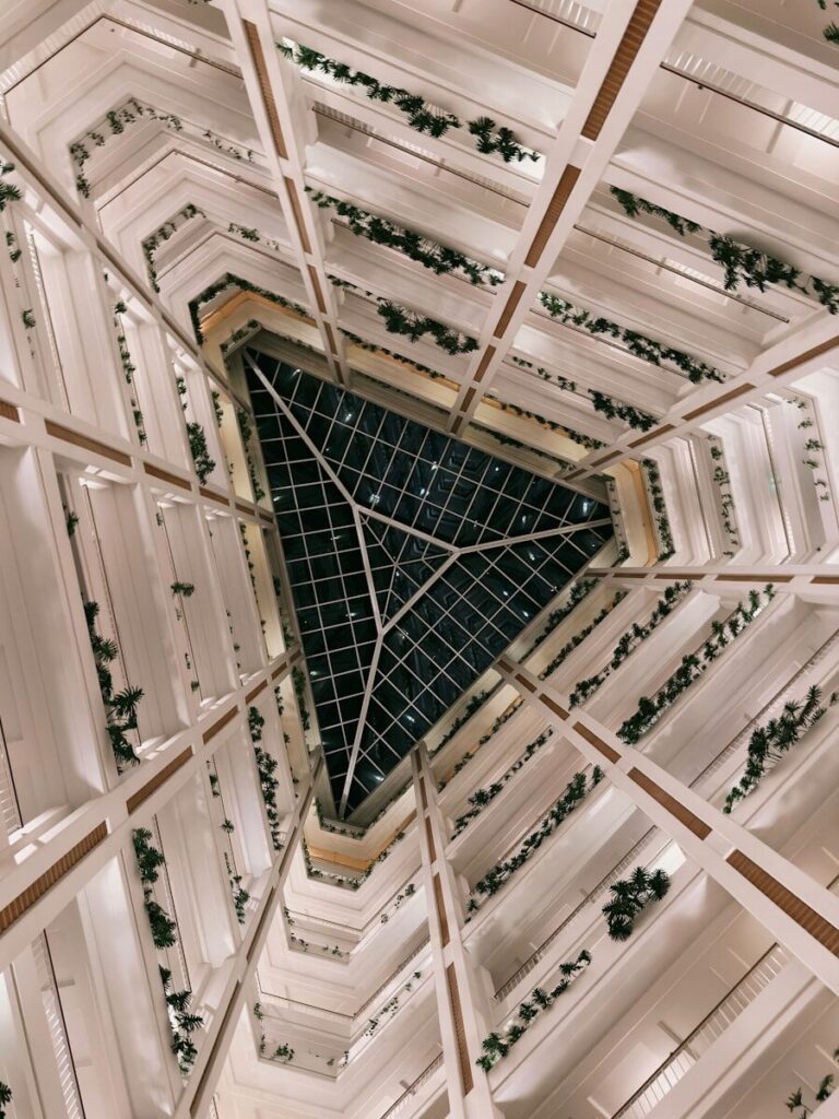 Looking up through a hotel atrium with glass ceiling