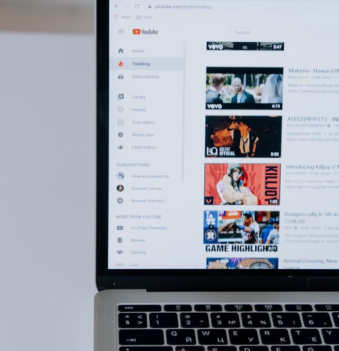 Person browsing YouTube videos on a laptop, showcasing modern technology and online content.