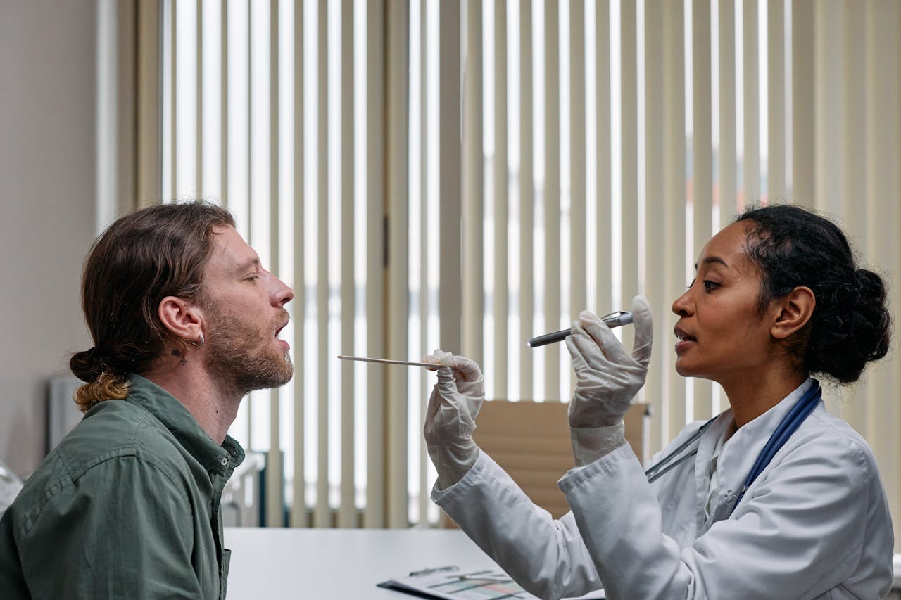 A doctor examining a patient's throat in a clinical setting, highlighting professional healthcare.